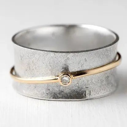 Silver ring decorated with cubic zirconia in an antique gold line 
